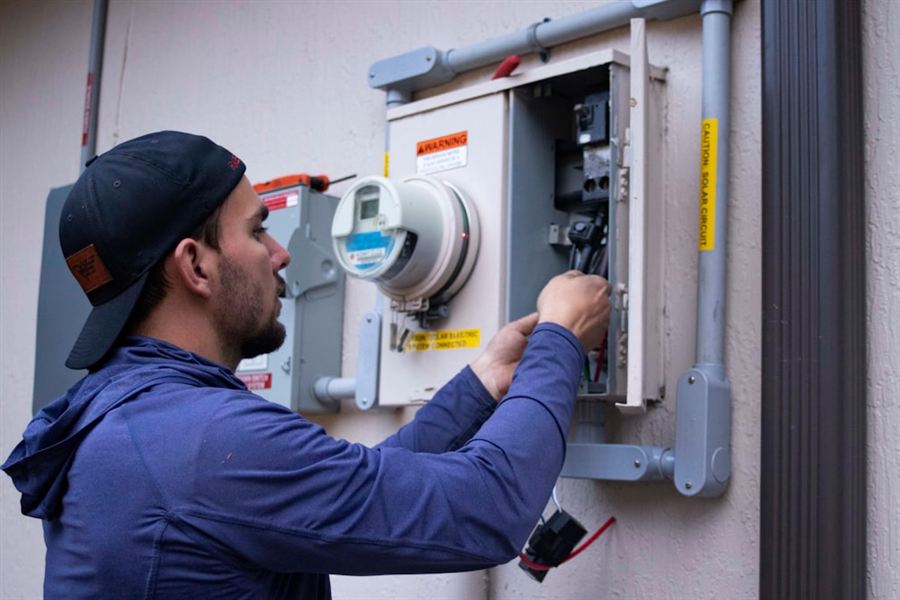 Electrician checking a solar system's connections during a maintenance visit